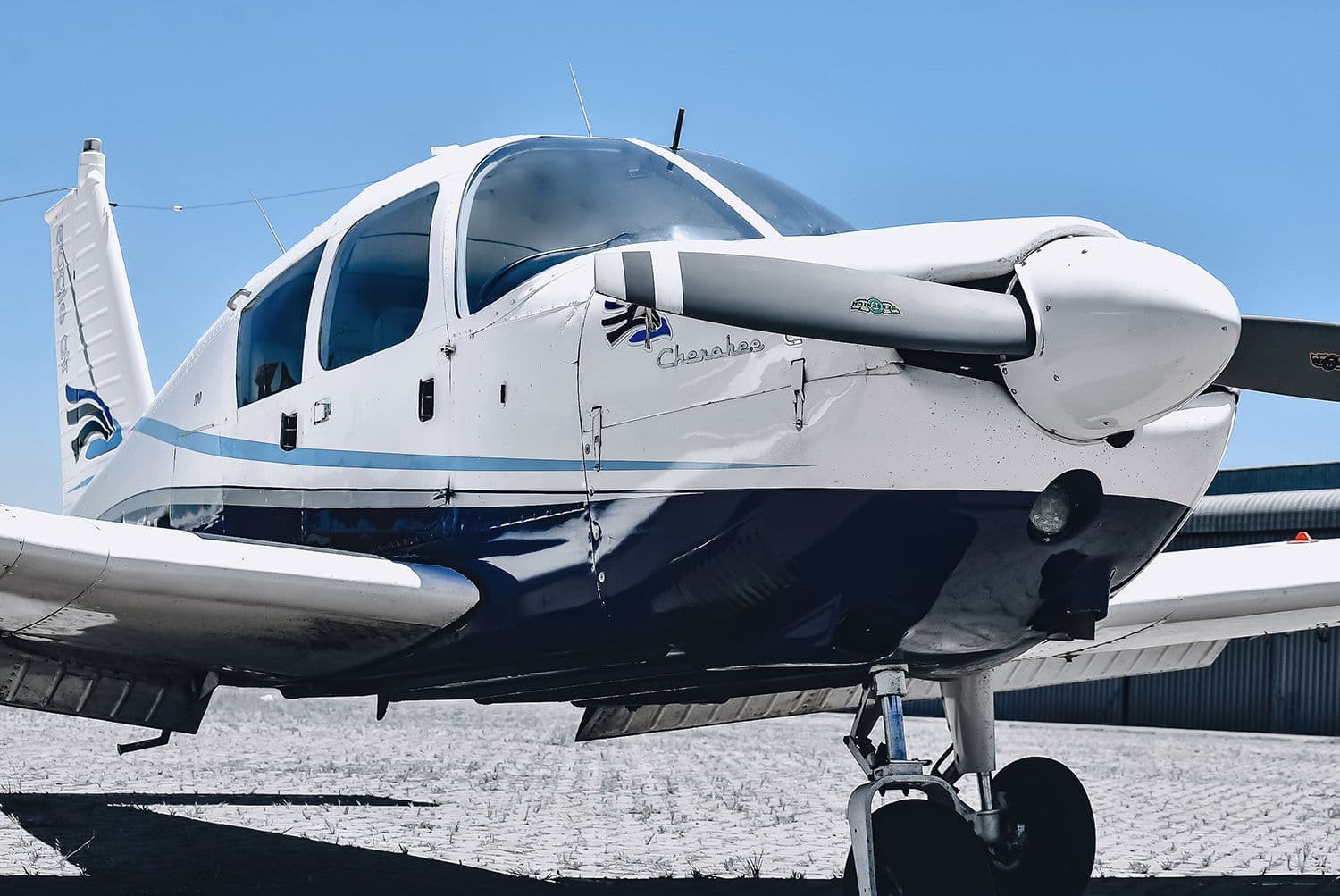 A Piper Cherokee parked on the apron in the sun