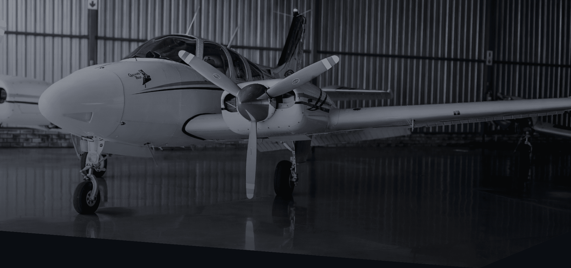 A Beechcraft Baron 55 waiting in the dark of the Eagle Air hangar